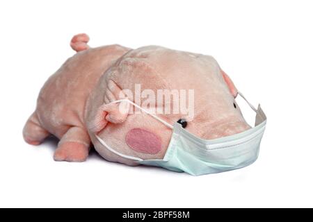 Stuffed toy pig with a medical face mask isolated on white background, Covid-19 coronavirus epidemic and children concept Stock Photo