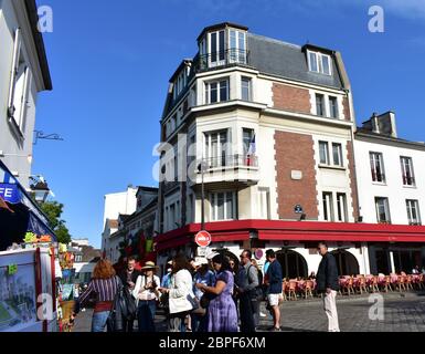 Montmartre neighbourhood with tourists, shops and cafes on a sunny day. Paris, France. Stock Photo