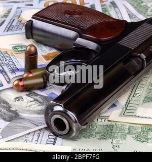 Pistol with bullets on the banknotes of American dollars, crime or corruption concept. Stock Photo