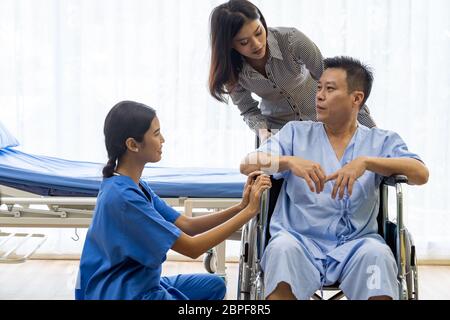 Physical therapist explain treatment method to senior patient and relative Stock Photo