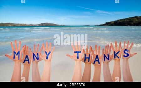 Many Hands Building English Word Many Thanks. Beautiful Beach, Ocean And Sea As Background Stock Photo