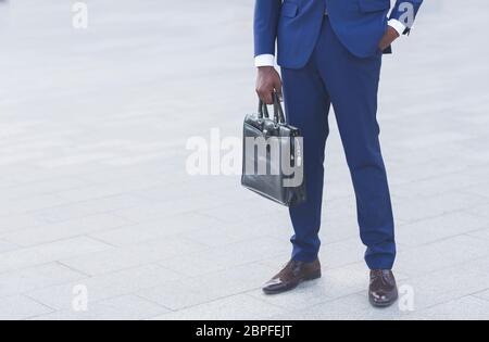 Unrecognizable Black Businessman Standing Holding Briefcase Outdoors, Cropped Stock Photo