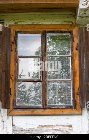 Old traditional polish wooden house in open air museum, Museum of the Kielce Village ( Muzeum Wsi Kieleckiej), window with handmade lace curtain, Toka Stock Photo