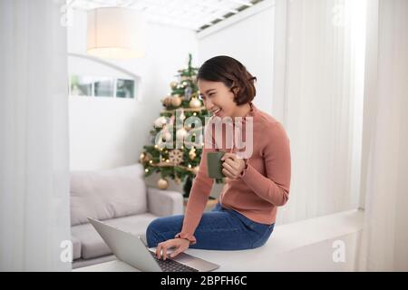 Asian woman using laptop at home Stock Photo