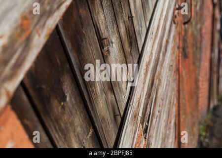Old wooden gate with metal handles and reddish paint build-up on the wood rusty risk of injury attention safety Stock Photo