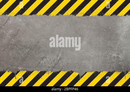 Concrete weathered wall background with yellow and black painted grunge hazard sign stripes and copy space Stock Photo