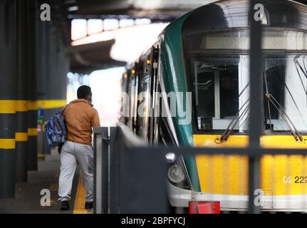 A man boards a train in Heuston station, Dublin, as phase one of Ireland's five phase exit plan was triggered on Monday. Stock Photo