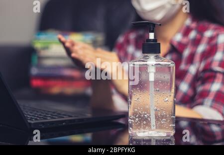 people washing hand by hand sanitizer alcohol gel for cleaning and disinfection, before typing on keyboard for working. prevention of germ spreading Stock Photo