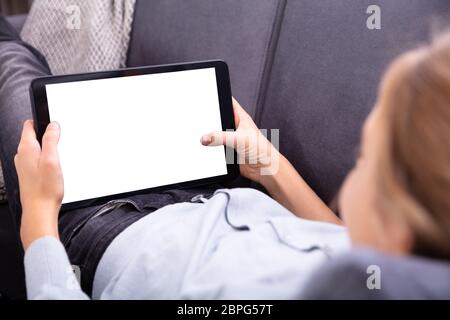 Close-up Of A Girl's Hand Using Digital Tablet With Blank White Screen Stock Photo