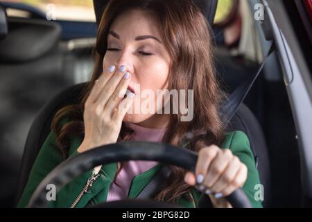 Portrait Of A Young Woman Yawning Inside Car Stock Photo