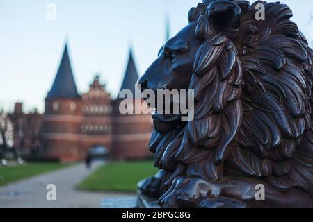 Holstentor in Lübeck with lion statue in the foreground UNESCO World Heritage Site landmark Gothic style historic cityscape ornaments restored brick P Stock Photo
