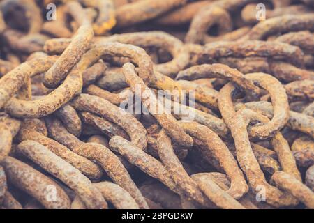 Close up of old rusty, rusting ironwork chain links. Pile of corroded, industrial, metal linking chains. Industry history. Stock Photo