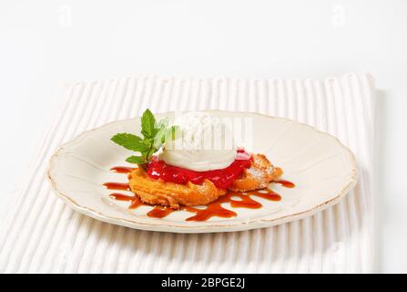 Spritz butter cookie with raspberry sauce and scoop of white ice cream Stock Photo