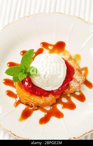 Spritz butter cookie with raspberry sauce and scoop of white ice cream Stock Photo