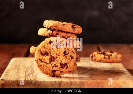 Chocolate chip cookies on a dark rustic wooden background, with a place for text Stock Photo