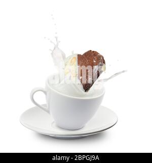 cookie falls into milk cup with splash, on white background Stock Photo