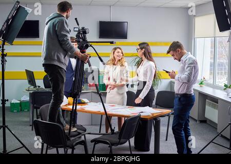 Film director discussing movie plan with the actors in the office scene. Lights pointing to the actors Stock Photo