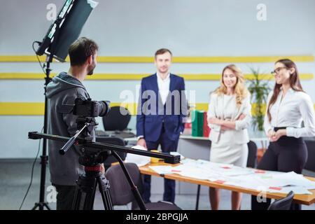 Film director discussing movie plan with the actors in the office scene. Lights pointing to the actors Stock Photo