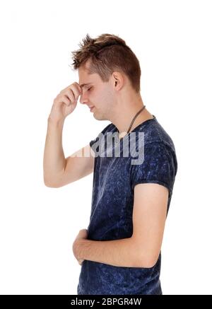 A young man standing in profile with one hand on his head and closed eyes, concentrated in his thoughts, isolated for white background Stock Photo