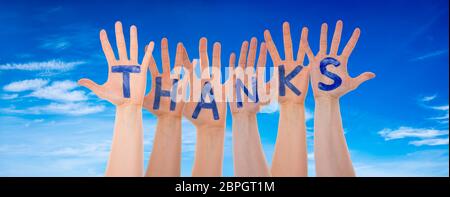 Many Hands Building English Word Thanks. Blue Cloudy Sky As Background Stock Photo