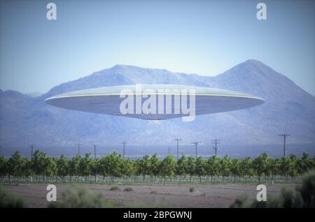 Unidentified flying object - UFO, flying over plantations in desert place with mountains behind. Stock Photo