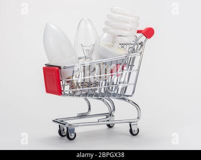 In the grocery cart are three light bulbs: incandescent, energy-saving and LED Stock Photo