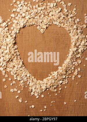 Heart shape of organic oat meal on a rustic wooden oak plank Stock Photo