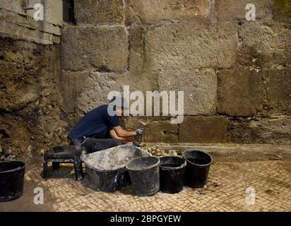 Jerusalem, Israel. 19th May, 2020. A worker repairs a mosaic floor unearthed by the Israel Antiquities Authority on Tuesday, May 19, 2020, in the Old City of Jerusalem. Archeologists have discovered an unique subterranean system in the bedrock of the Second Temple Period beneath a 1400 year-old public building in the underground excavations under the Western Wall. Photo by Debbie Hill/UPI Credit: UPI/Alamy Live News Stock Photo