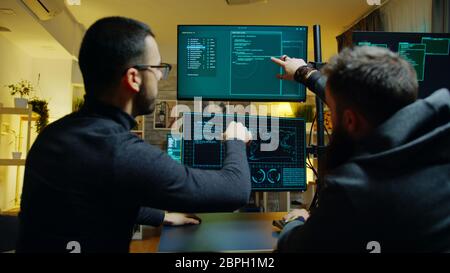 Team of cyber criminals hacking into the government server. Dark room. Stock Photo
