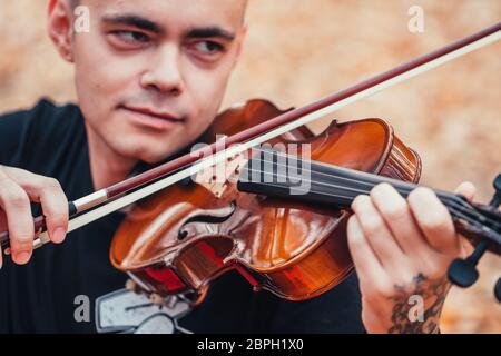 young man playing violin in the autumn forest. Stock Photo