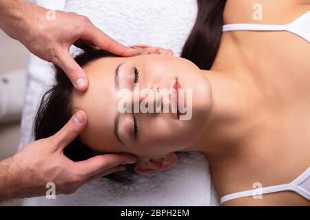 Close-up Of A Therapist Hand Massaging Young Woman's Head Stock Photo