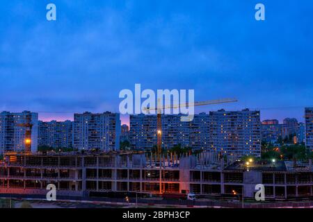 round-the-clock construction of social facilities. cranes at a construction site at night, night lighting is turned on. Stock Photo