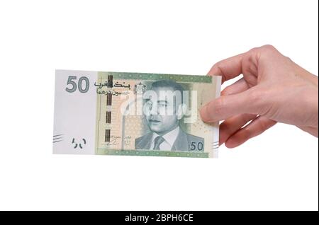 Female hand holding a 50 Moroccon Dirham banknote isolated on a white background. Denomination of 50 Dirhams. Stock Photo