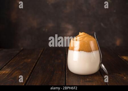 Dalgona coffee, a whipped trendy instant coffee against dark background Stock Photo