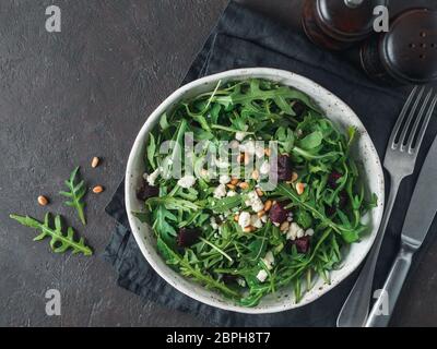 Beetroot, aragula and soft cheese salad over black background. Top view or flat lay. Copy space for text. Idea and recipe for healthy vegetarian salad Stock Photo