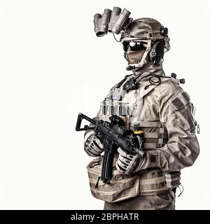 Army elite soldier with hidden behind mask and glasses face, in full tactical ammunition, equipped night vision device, radio headset, armed short bar Stock Photo
