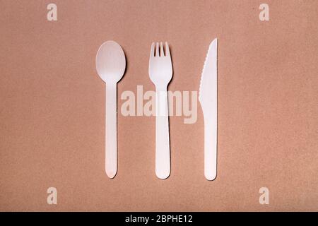 Set of wooden bamboo cutlery: fork, knife and spoon on natural paper background. Stock Photo