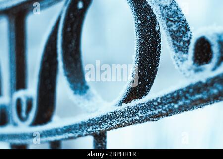 metal fence in hoarfrost on a blurred background. Stock Photo