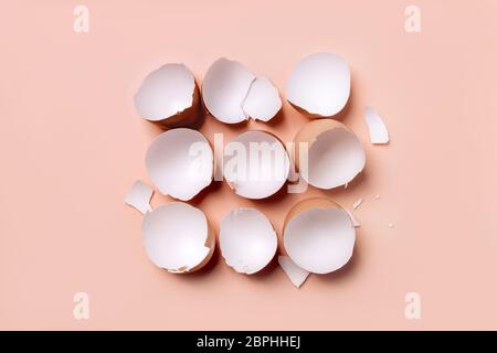 Broken eggshells in the middle of the light coral color background. Stock Photo