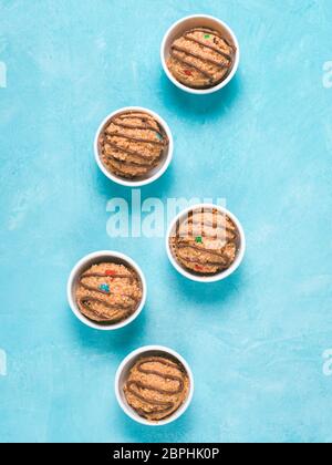 Safe-to-eat raw monster cookie dough in small portion bowl on blue background. Ideas and recipes for kids and toddlers meal. Top view or flat-lay. Cop Stock Photo