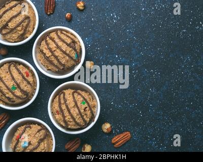 Safe-to-eat raw monster cookie dough in small portion bowl on dark blue background. Ideas and recipes for kids and toddlers meal. Top view or flat-lay Stock Photo