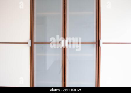 wooden white closet doors closeup for clothes modern new design with brown Stock Photo