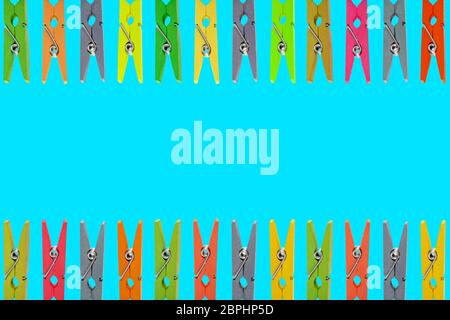 Colorful wooden clothespins on Blue background Stock Photo
