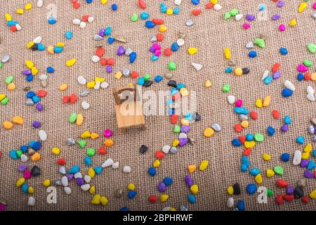 Little chair amid  pebbles on canvas background Stock Photo