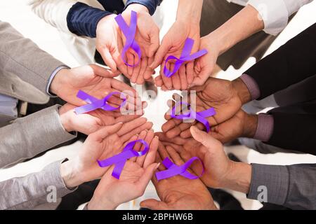 Group Of Businesspeople Holding Teal Ribbons To Support Pancreatic Cancer Awareness Stock Photo