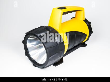big yellow flashlight hand held with adjustable angle isolated on white background.. Stock Photo