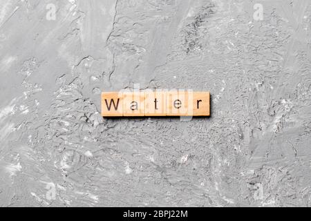 water word written on wood block. water text on cement table for your desing, concept. Stock Photo