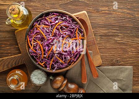 Healthy vegetable salad with red cabbage and carrots on wooden table Stock Photo