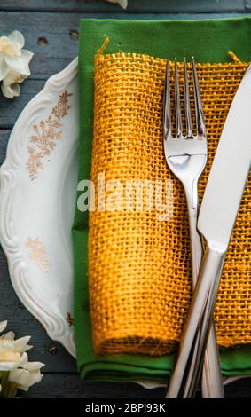 Spring table setting. Narcissus flower. Fork on Easter table. Holiday table setting Stock Photo