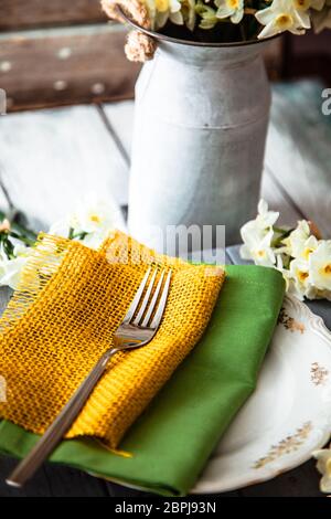 Spring table setting. Narcissus flower. Fork on Easter table. Holiday table setting Stock Photo